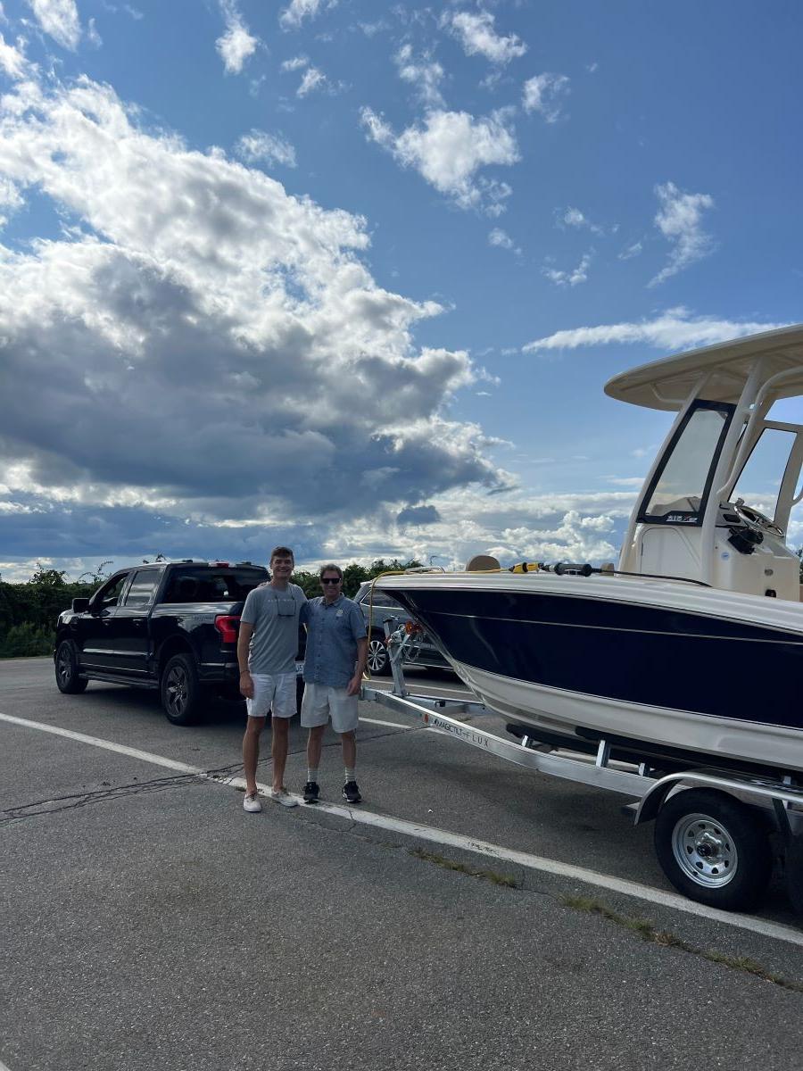 ReVision Energy co-founder Phil Coup and a friend in front of his electric boat